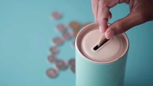 Kid Saving Coins in a Jar on Color Background