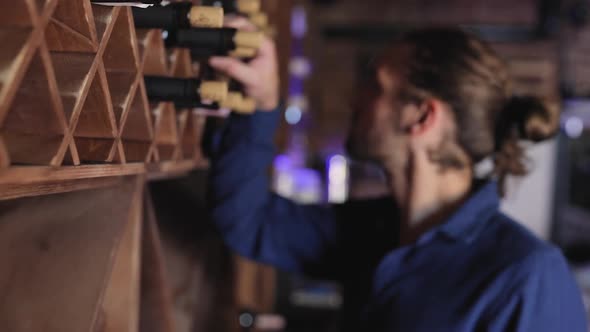 Wine Restaurant. Handsome Man Choosing Wine Bottle On Shelf