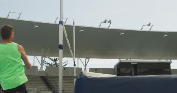 Side view of caucasian athlete doing high jump