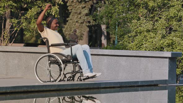 Mature African American Male Disabled in Wheelchair Waving Hands Doing Warmup Exercise Therapy