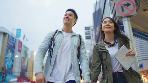 Asian active young couple travel in city for honeymoon trip at night.