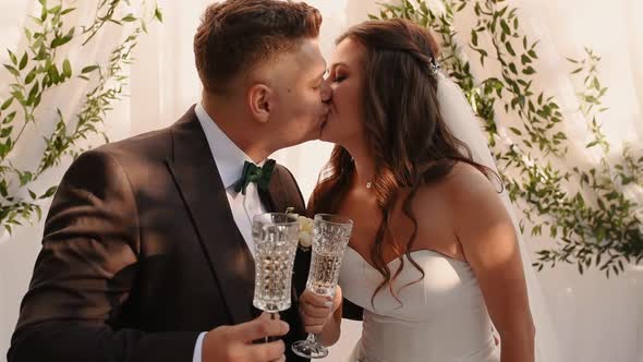 Groom and Bride in Dress Kiss Hugging Each Other