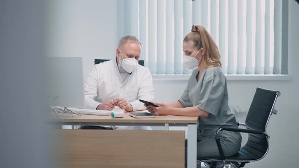 Medical Specialists Wearing Protective Medical Masks Discuss the Methods of Treating Patients an