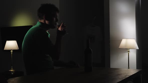 Upset Man Drinking Wine Alone in the Darkness
