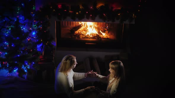 Woman Playing with Child By the Fireplace, Have a Nice Christmas Party Together