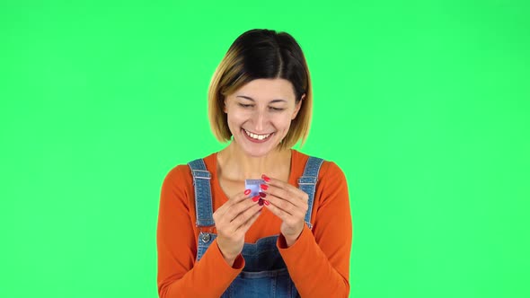 Girl Opens a Small Box with a Surprise and Is Very Disappointed with What She Saw. Green Screen