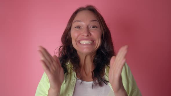 Happy Fun Woman Jumps and Claps Her Hands Looks at Camera Shocked Surprised Put Hands on Face