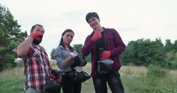 Portrait of Cheerful Team of Volunteers with Garbage Bags Show Thumbs at Camera