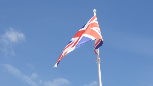 United Kingdom Union Jack flag in front of blue sky waving 4K 2160p UltraHD footage - Great Britain 