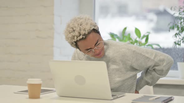 African Woman Having Back Pain While Using Laptop in Office
