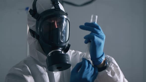 Paramedic in a Hazmat Suit Is Preparing a Syringe for an Injection