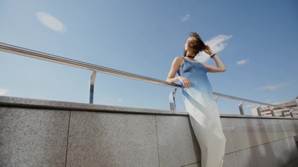 Beautiful Girl In Long Dress Posing In The Wind In City Street