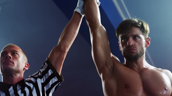 Boxer holding winner hand after announcing victory