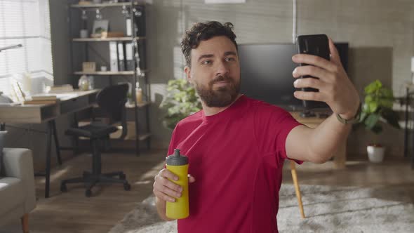 Tired Guy Drinking Water Taking Break in Workout at Home