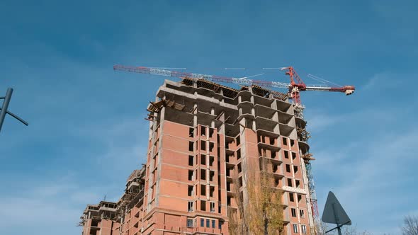 View of the high-rise building under construction. Tower crane.