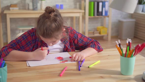 Portrait of a Lonely Child Autism or Having Mental Disorders Draws Sitting at a Table