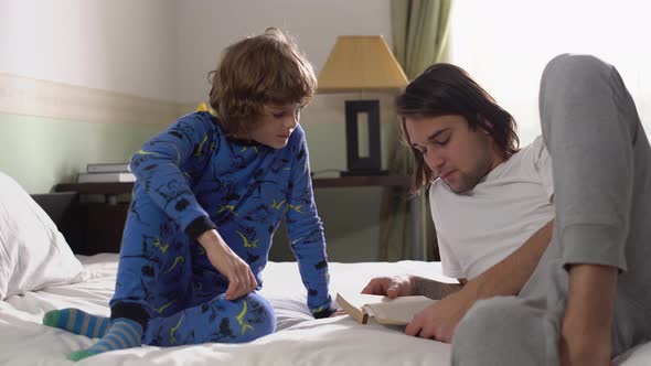 Two Brothers Lie Down in Bed, Older Brother Read for Small Brother a Book