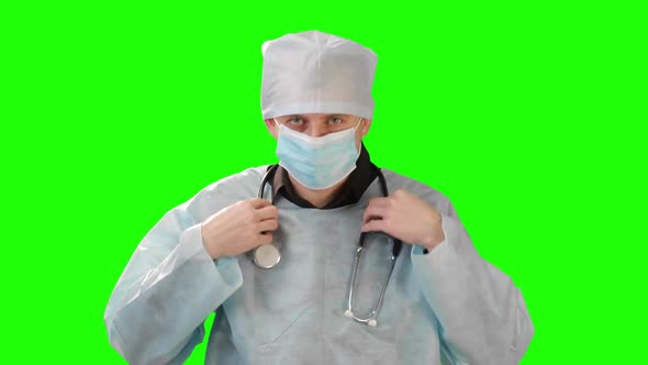 Scientist Medic Dressed in a Surgical Gown Wears Clothes for the Neck Stetoskop . Video on Chromakey