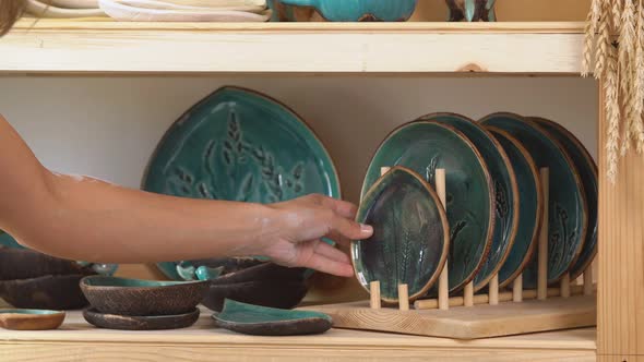 Girl Ceramist Puts the Finished Product on the Shelf Before Selling