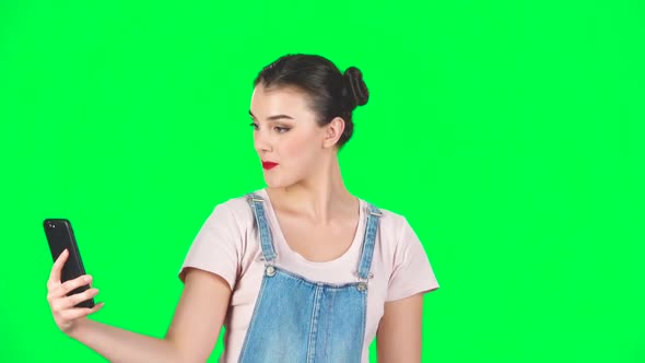 Young Woman Makes Selfie on Mobile Phone Then Looking Photos on Green Screen, Slow Motion