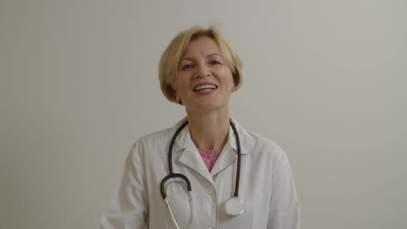 Portrait of Confident Middle Aged Female General Practitioner Looking with Friendly Smile at Clinic