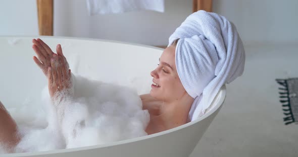 Closeup Beauty Portrait of Pretty Woman Chilling at Home Resting in Bathtub with Foam Washing Her