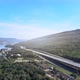 beautiful expressway in a green forest with a dam on the side of the road between mountains. - VideoHive Item for Sale