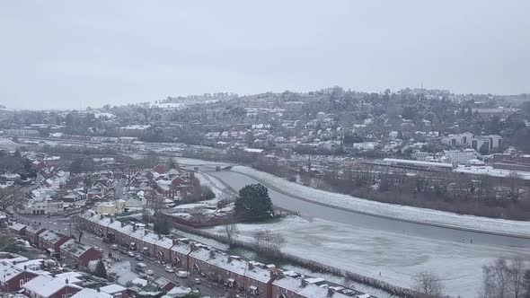 Track forward panning drone shot of snowy Exeter over the River Exe CROP