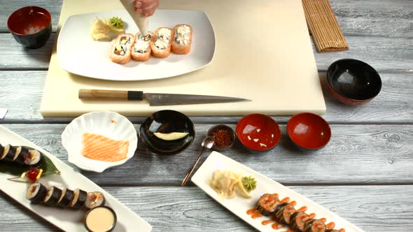 Hand with Tool Prepares Sushi.