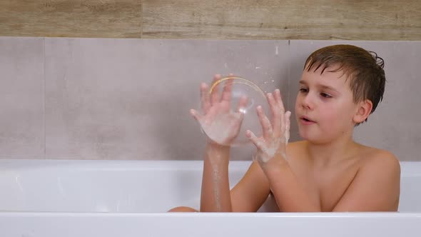 Boy Playing in Bathroom Child Bathe and Inflates Soap Bubbles