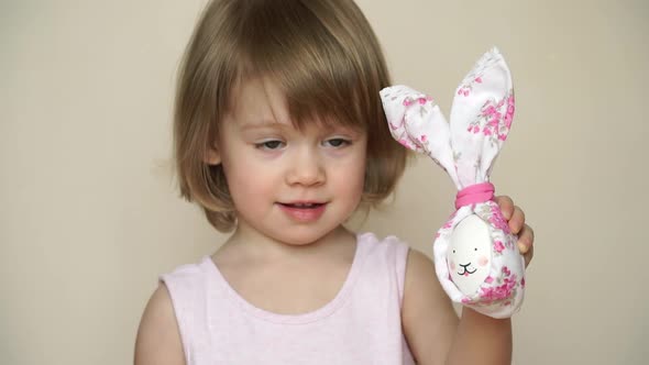 Little Girl Holds Chicken Egg Decorated for Easter Bunny