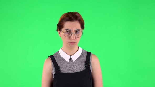 Portrait of Funny Girl in Round Glasses Is Very Offended and Looking Away. Green Screen