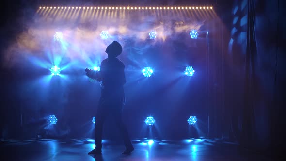 Silhouette of Black Man Who Dances a Folk Dance and Plays the African Percussion Drum Shekere