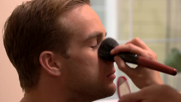 Hand Applying Makeup on Man.