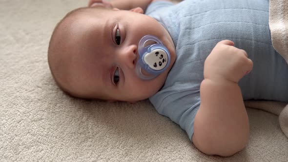 Closeup Cute Funny Kid 2 Month Newborn Boy With Pacifier Looking At Camera After Bath Shower On