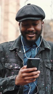 African American Man in Hat Listening to Music Outdoors