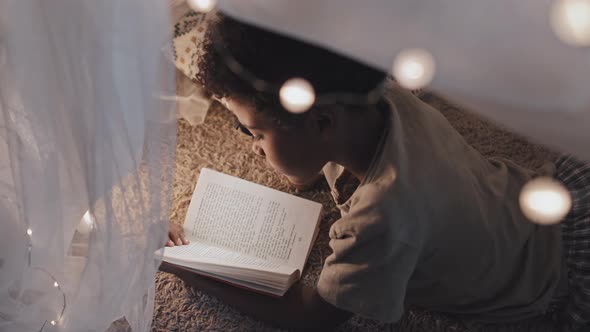 Kid Reading in Pillow Fort