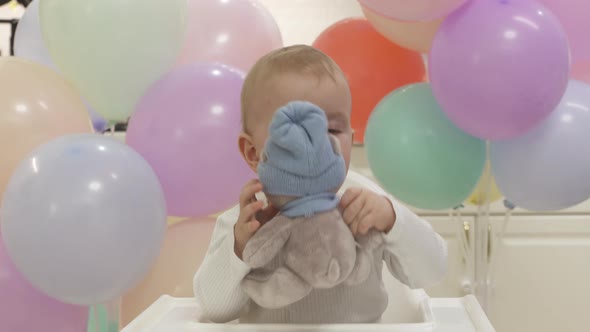 Happy Baby Boy Playing with a Toy at His First Birthday Party Oneyearold Child Against the