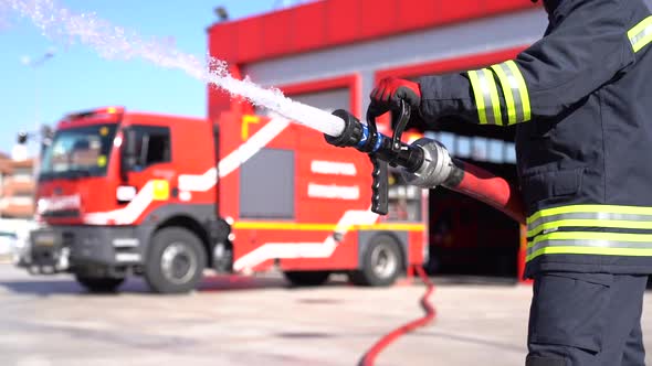 A fireman keeps fire hose for training. Slow motion and close up shot. Fire station background.