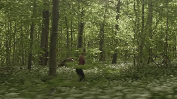 Lush Green Forest Surrounded By Plants and Trees and a Woman Running Fast