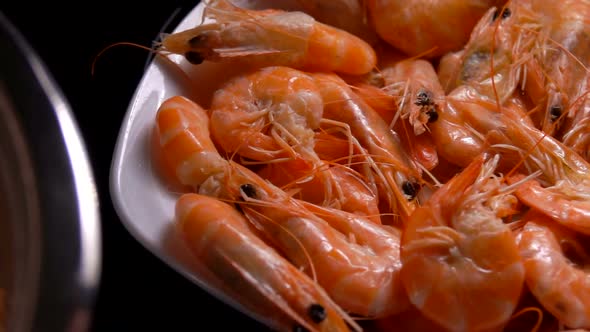 Cooked Shrimps Fall Into a White Plate