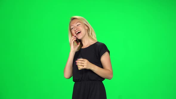 Cute Girl Goes and Speaks By Phone While Holding a Paper Cup of Coffee