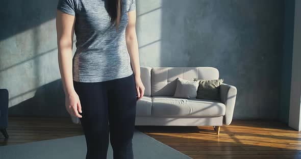 Worried Woman Stands on Digital Scales in Living Room