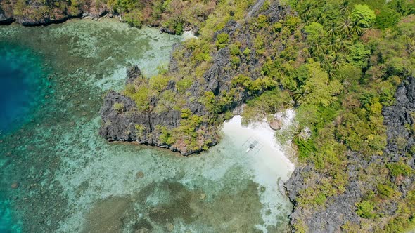 Aerial Circle Footage of Small Beach Near Big Lagoon with Lonely Banca Local Boat on Paradise Sandy