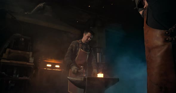 Two Blacksmiths Forge a Redhot Piece