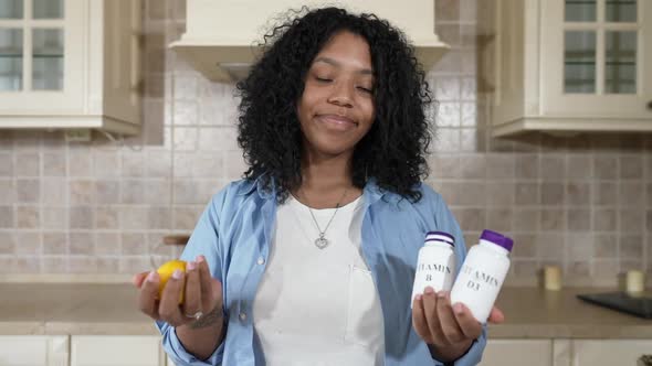 Portrait of Smiling Beautiful African American Woman Choosing Organic Healthful Lemon Vs