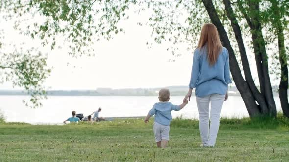 Mother and Toddler Watching Boat on Lake alt