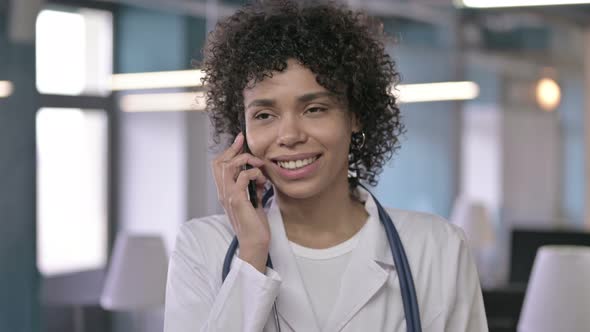 Portrait of Professional Young Doctor Smiling and Talking on Smart Phone