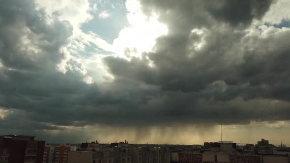 The Rapid Movement of Rain Clouds Over the Metropolis. Salt Rays Break Through the Gaps in the