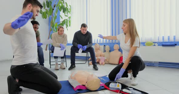 Stay Away Moment During the Defibrillation Process on a First Aid Group Training Indoors